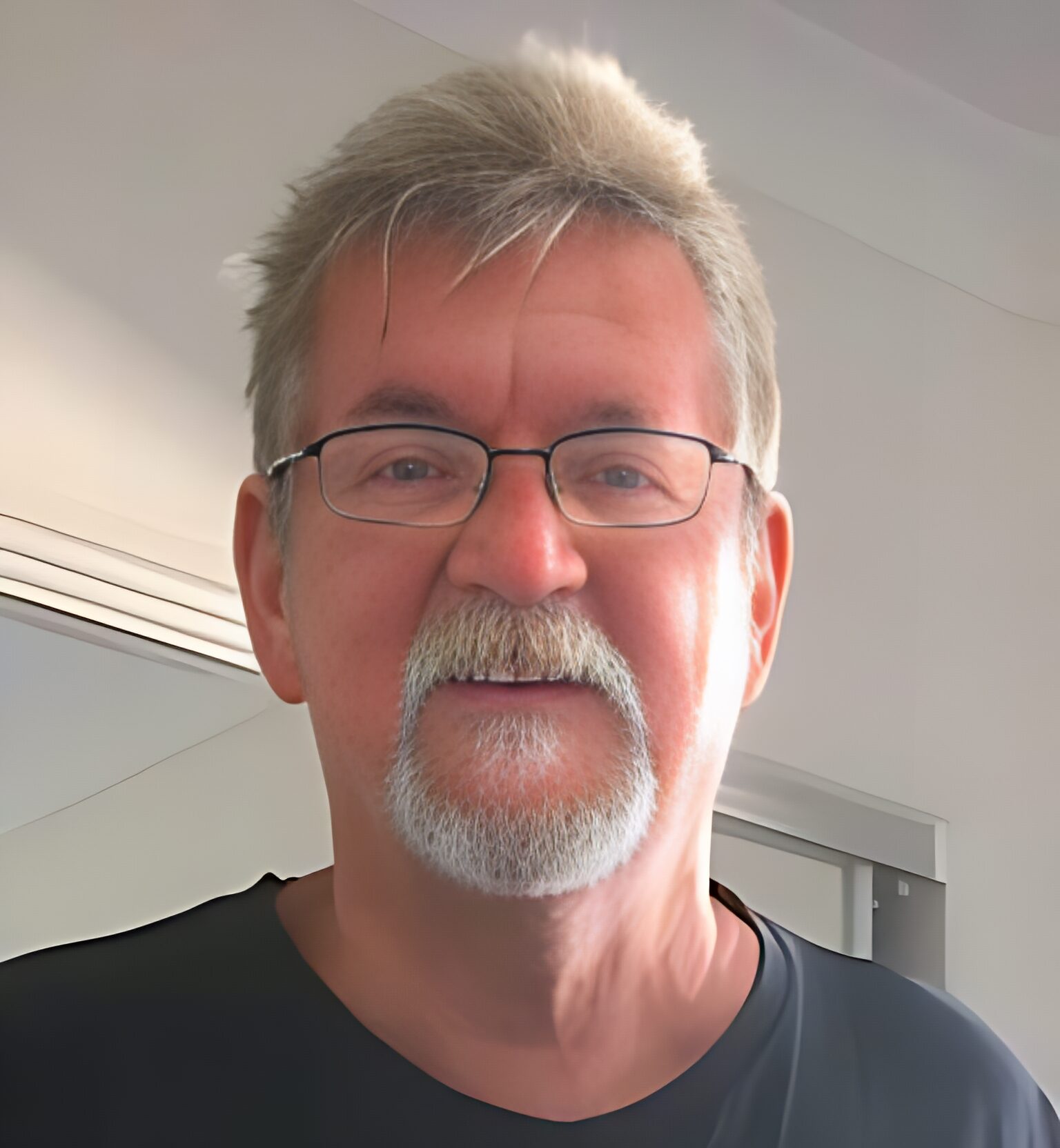 Lee Smiling man with glasses and gray hair